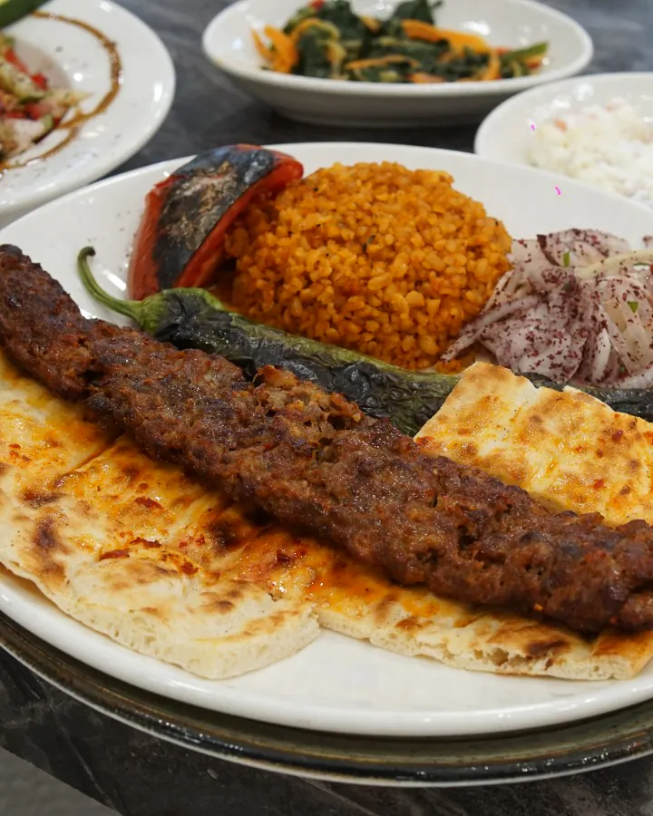 Lavaş üstünde Adana kebap ve bulgur pilavı